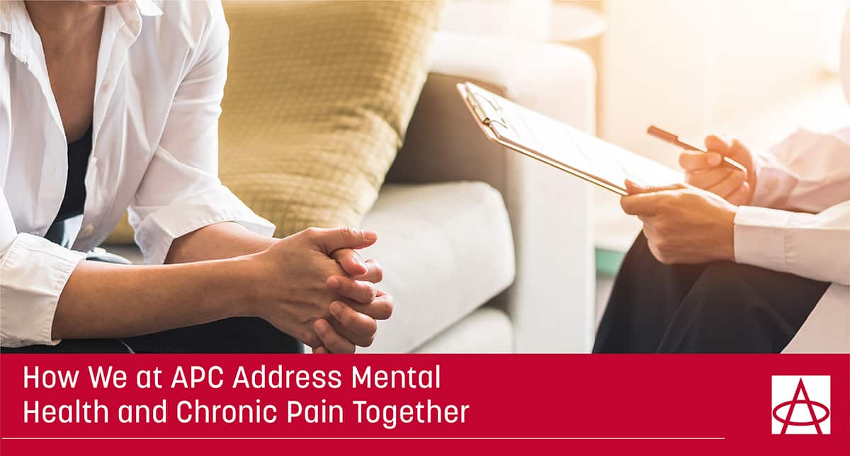 header image for blog A woman sits forward with her hands clasped together on a couch accross from a doctor with a clipboard the caption says How We at APC Address Mental Health and Chronic Pain Together