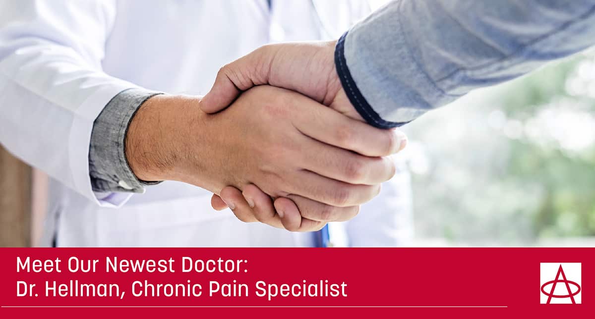 header image for the blog a doctor in a white coat is shaking hands with a man in a grey long sleeve shirt the caption reads meet our newest doctor dr. hellman chronic pain specialist